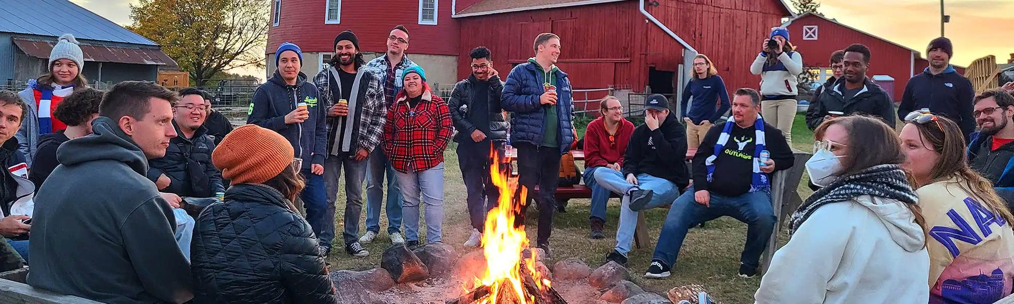 adults around a bonfire at round barn