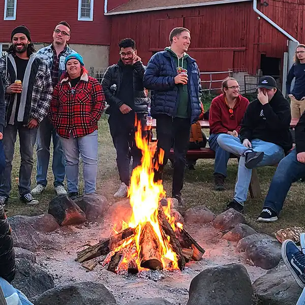 adults around a bonfire at schusters farm