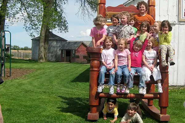 kids in a giant rocking chair photo prop